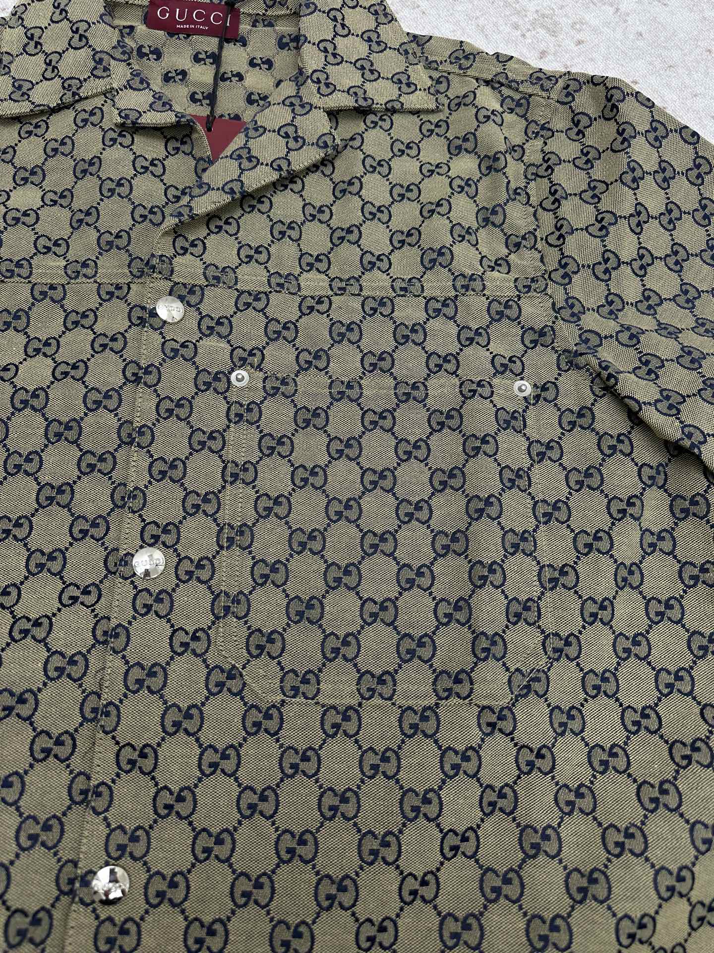 Gucci short-sleeve shirt front close-up with GG pattern and metal button details