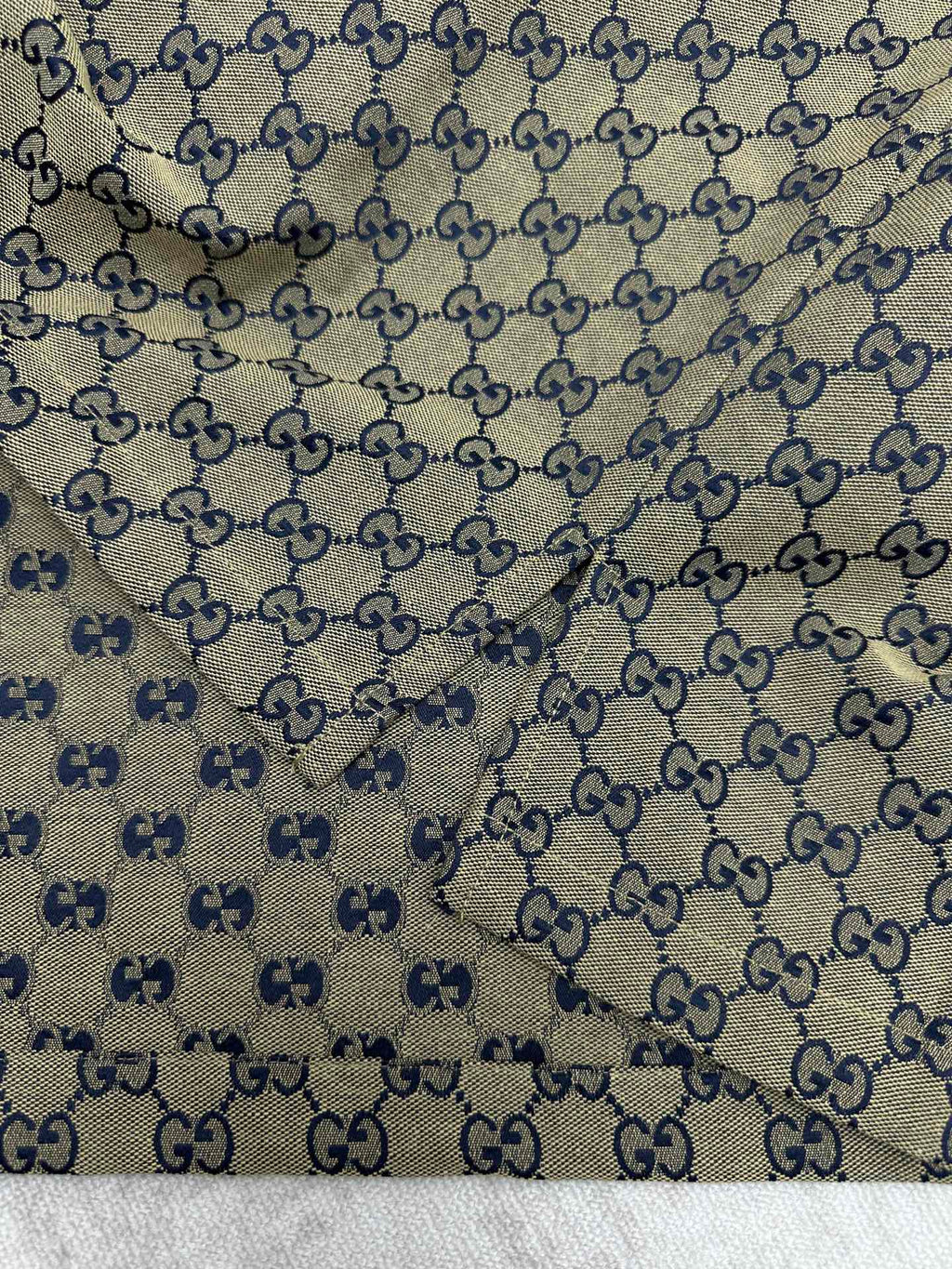 Gucci short-sleeve shirt fabric close-up with GG logo pattern and blue motif