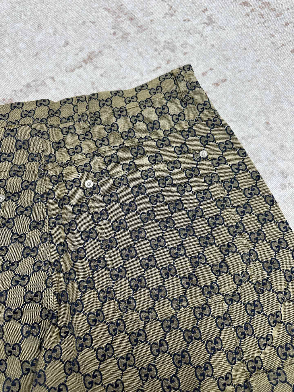 Gucci shorts close-up with GG monogram print and metal button