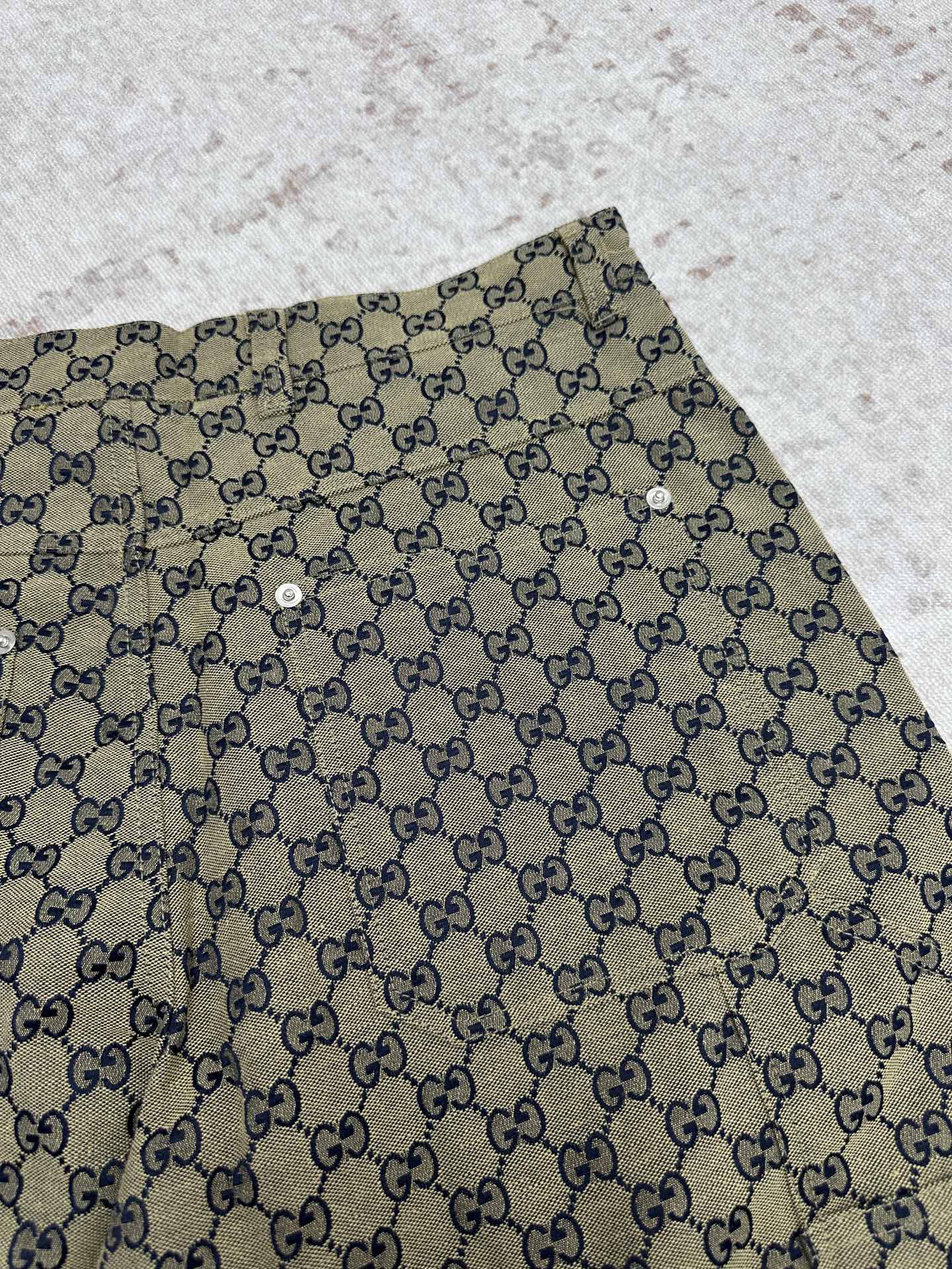 Gucci shorts close-up with GG monogram print and metal button