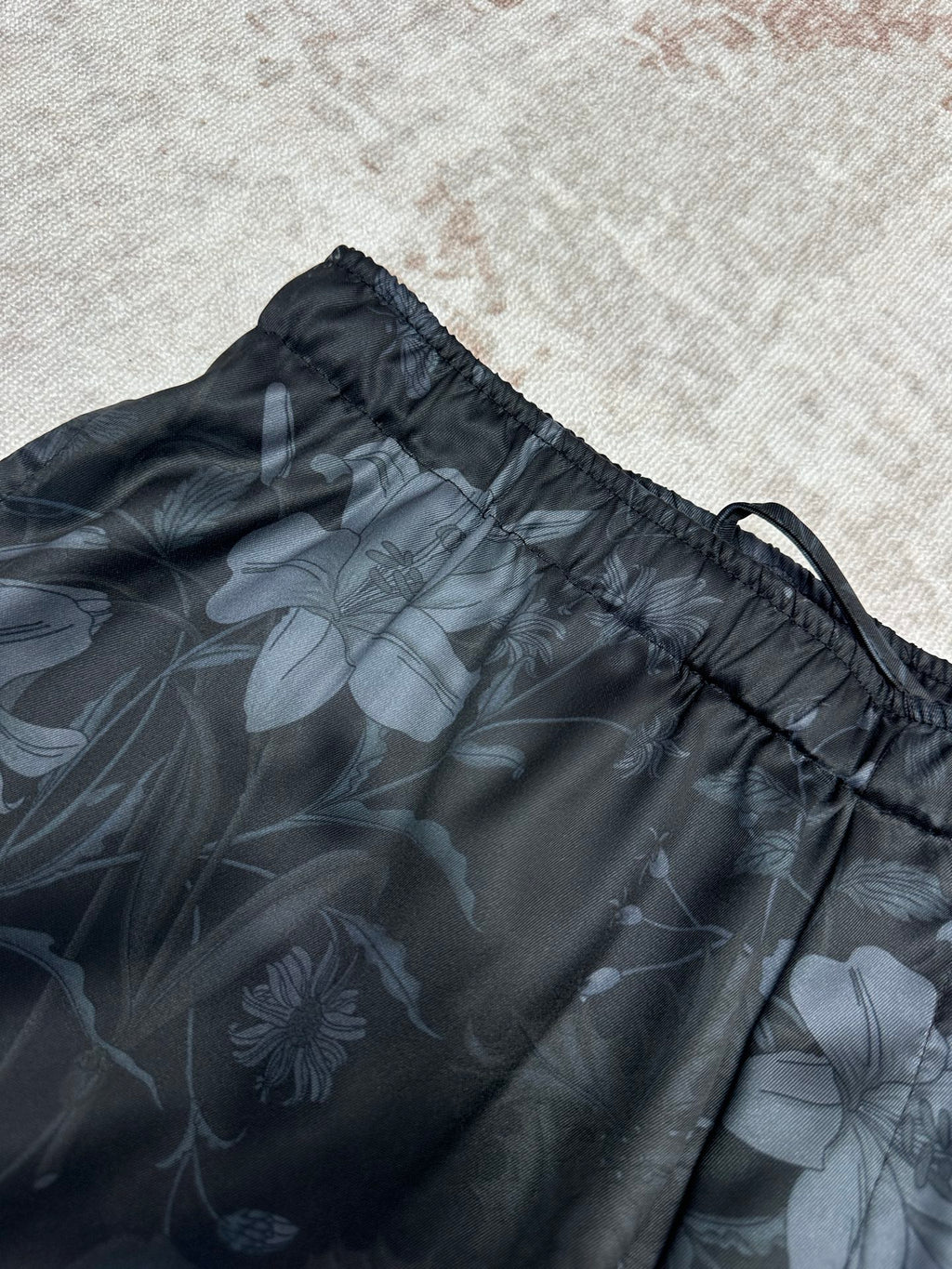 Dark floral shorts close-up with gathered elastic waist