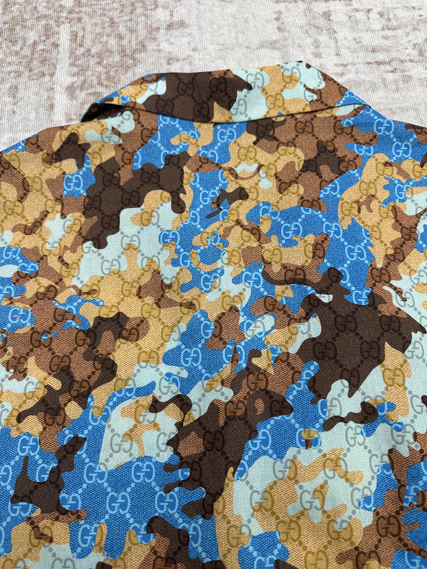 Short-sleeve button-up shirt with blue and brown bear print, side view