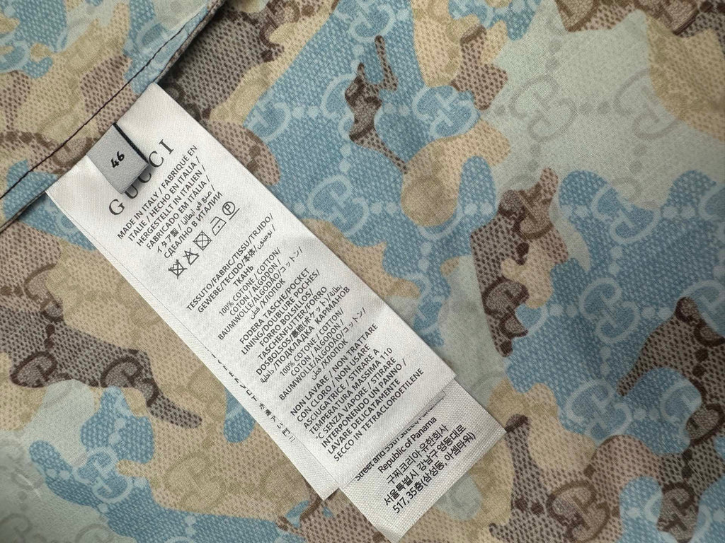 Shirt care label tag attached to blue and tan bear print fabric