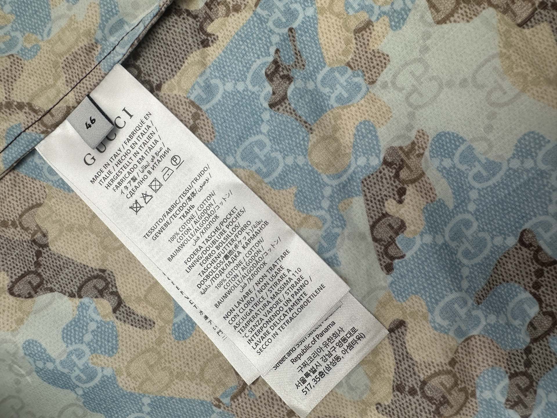 Shirt care label tag attached to blue and tan bear print fabric