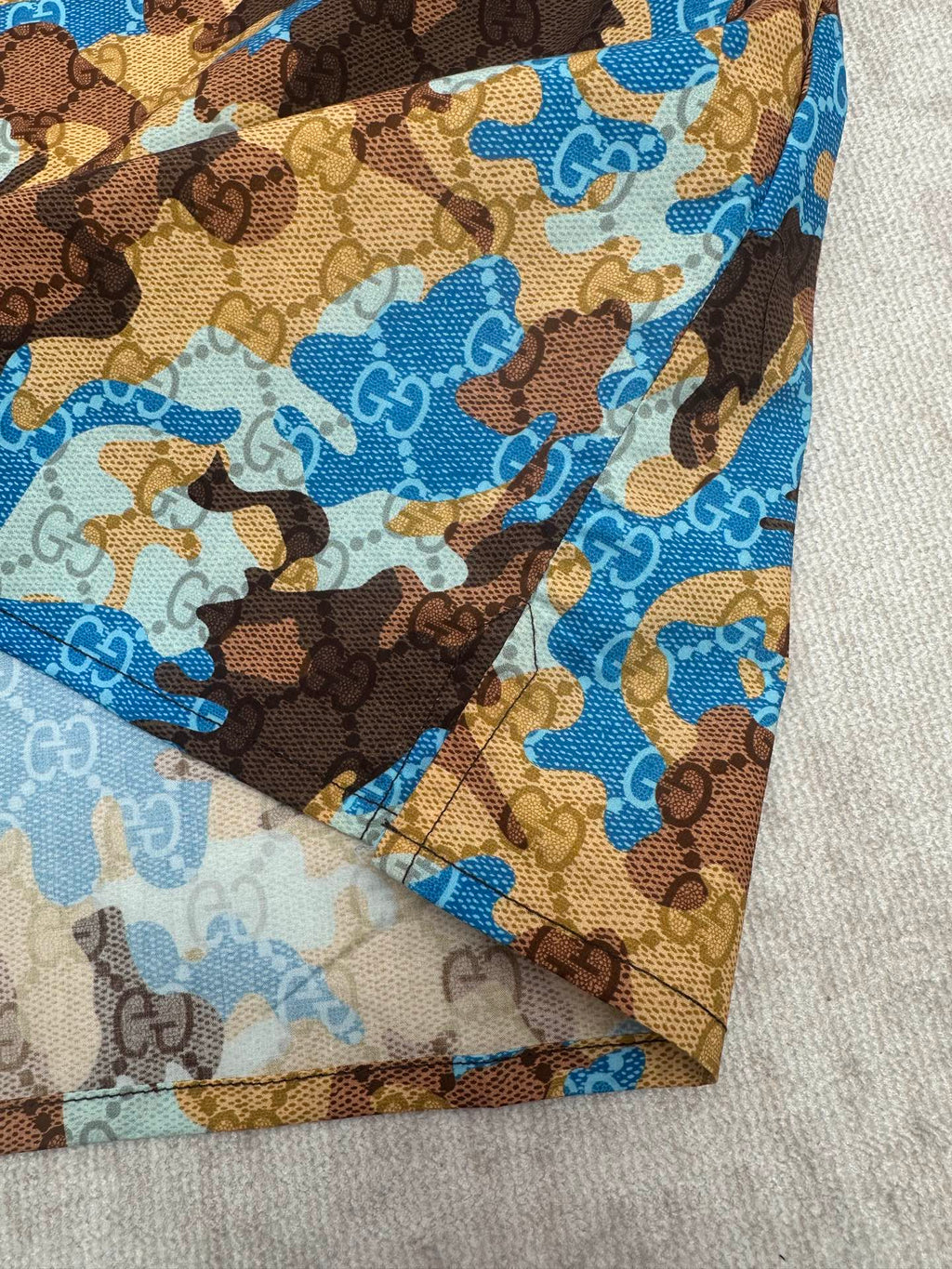 Short-sleeve shirt fabric close-up in blue and tan bear print