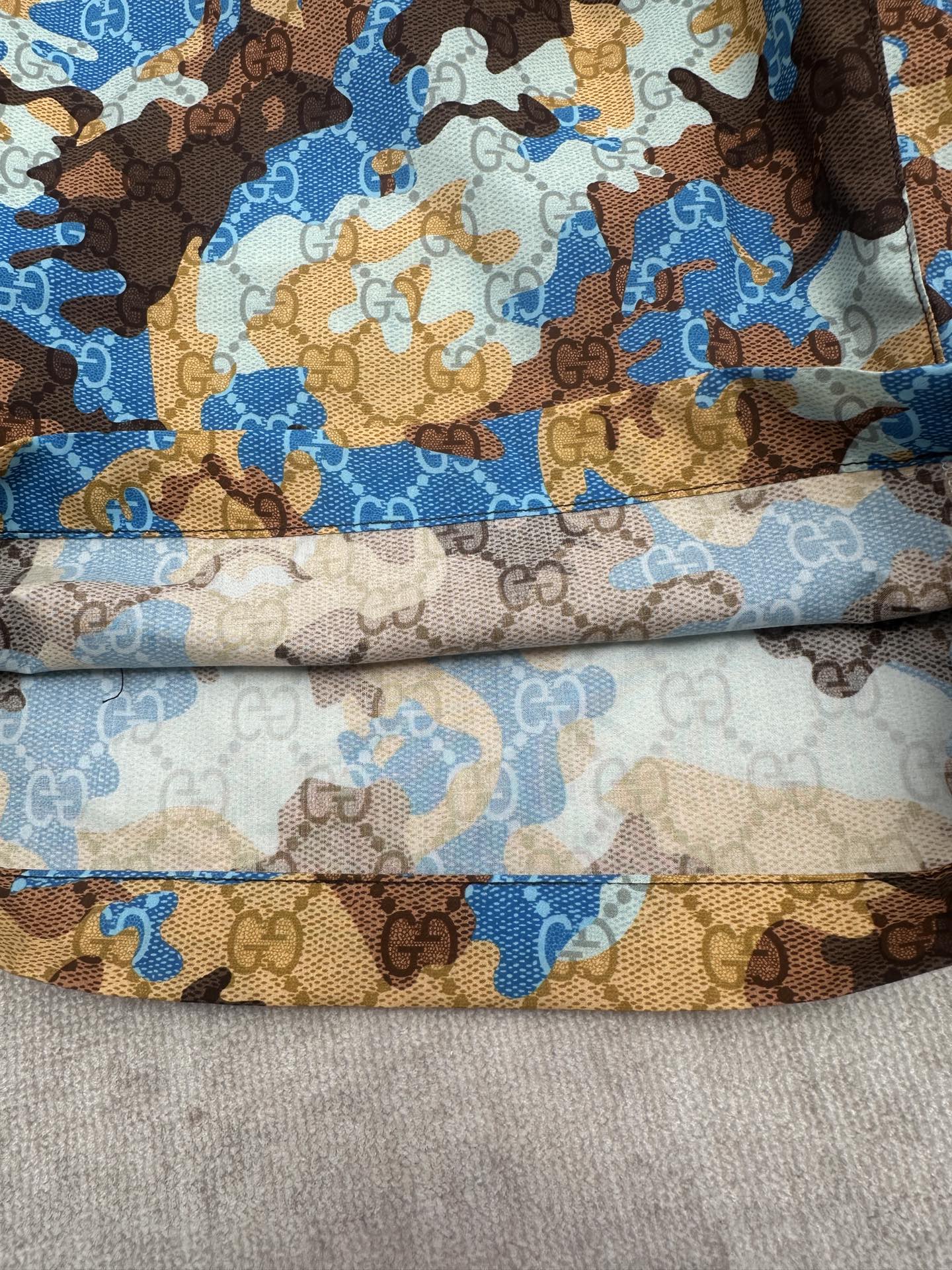 Gucci shorts folded close-up showing blue and brown print and light lining