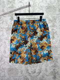 Gucci shorts in blue, brown, and tan camouflage-style print with elastic waistband