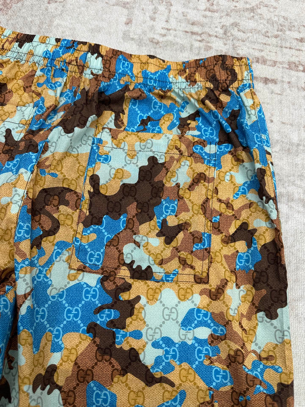 Gucci shorts waistband and side panel with blue, tan, and brown allover print