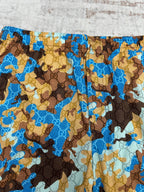 Close-up of Gucci shorts fabric with blue, tan, and brown patterned design