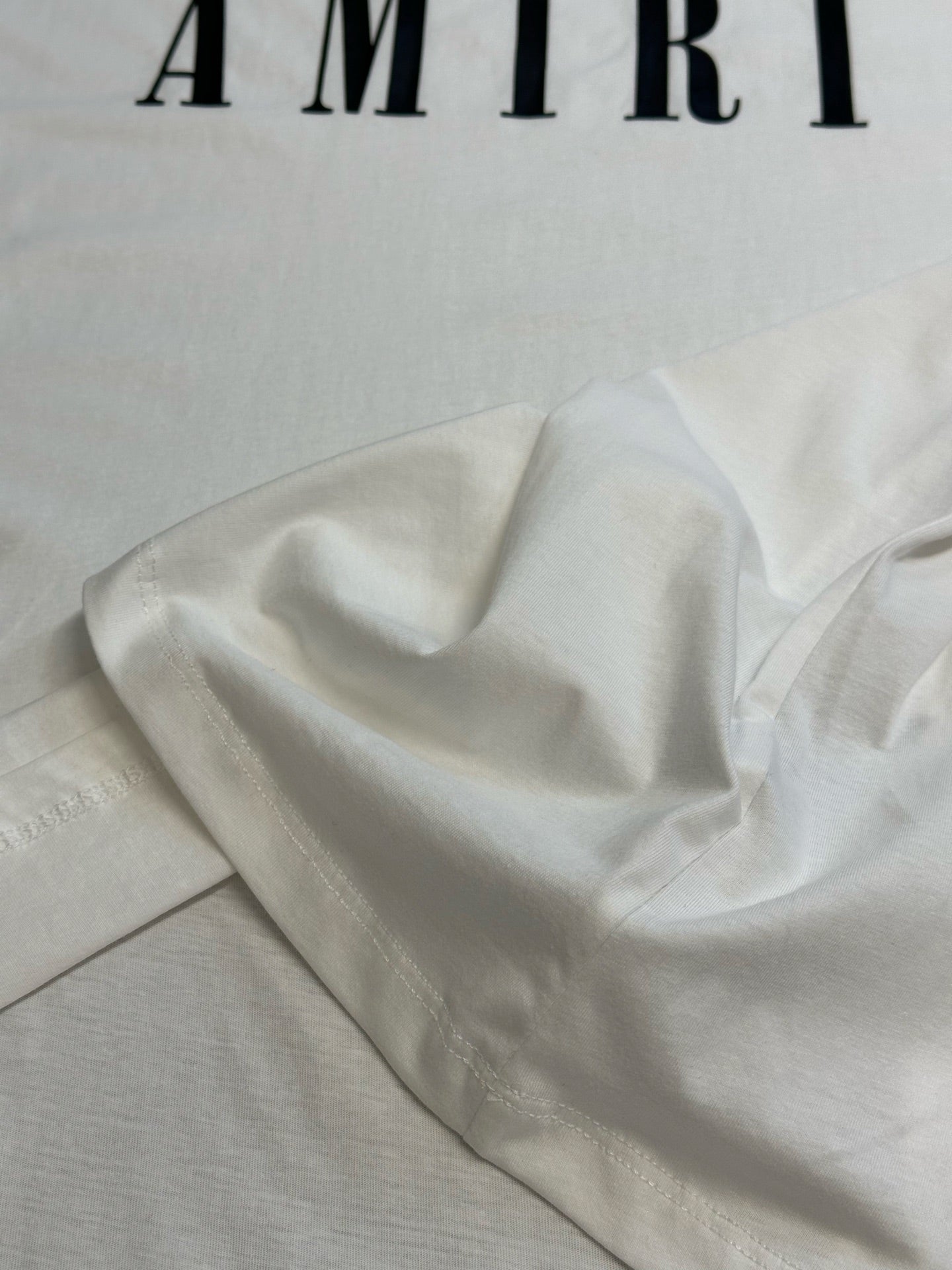 White T-shirt fabric drape close-up with soft cotton texture.