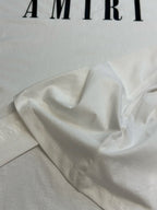 White T-shirt fabric drape with partial AMIRI logo at top