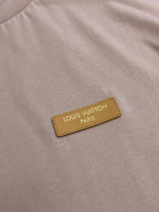 Leather-look logo patch with text on a light pink T-shirt