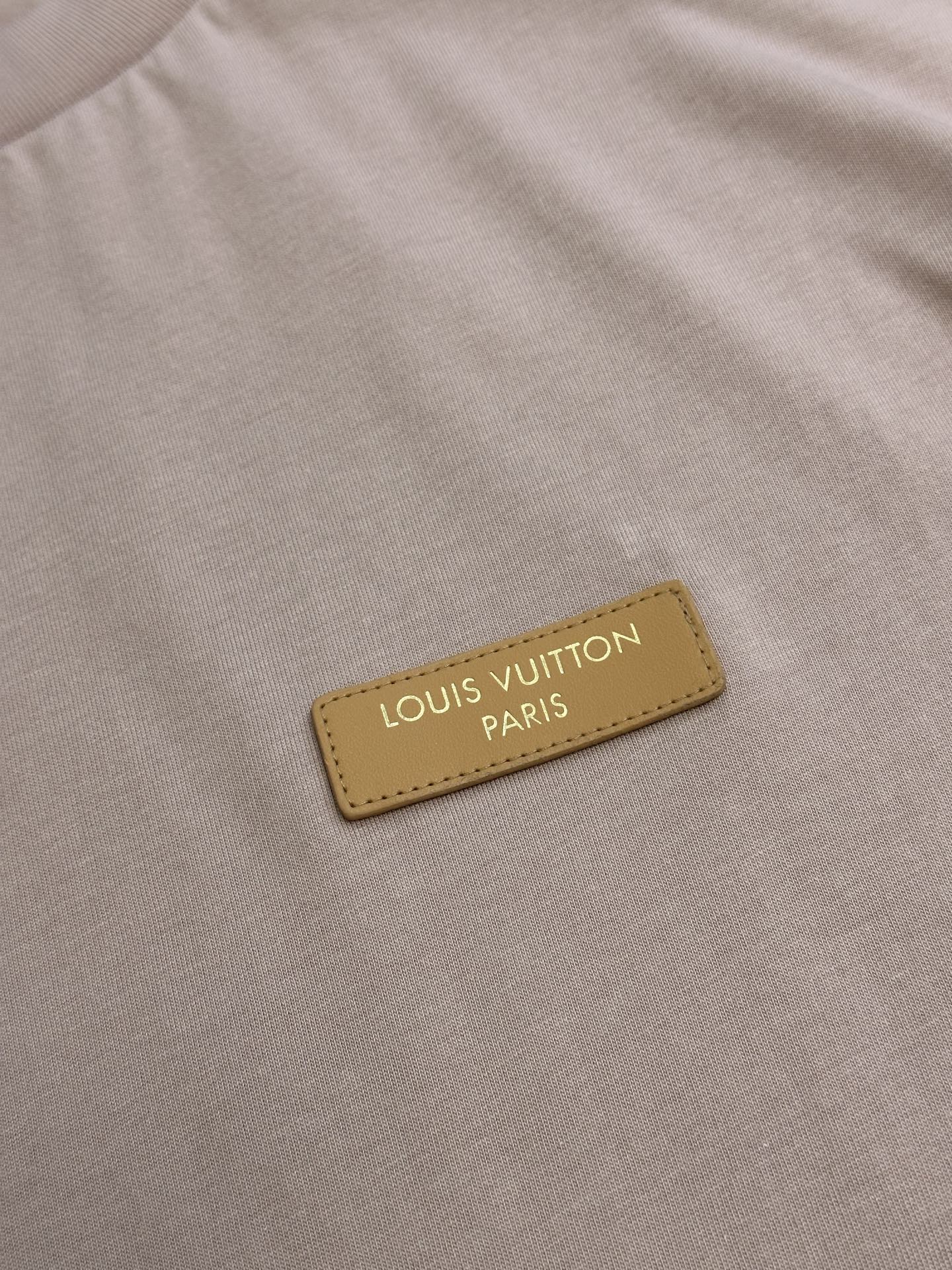Leather-look logo patch with text on a light pink T-shirt