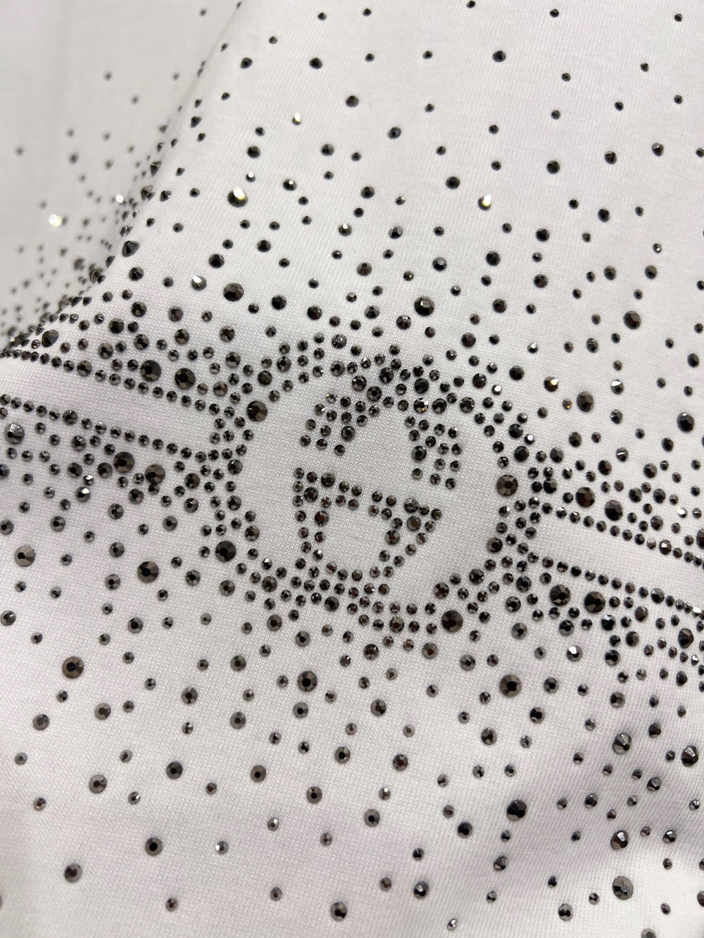Gucci white T-shirt detail: dense rhinestone speckle fabric with centered logo