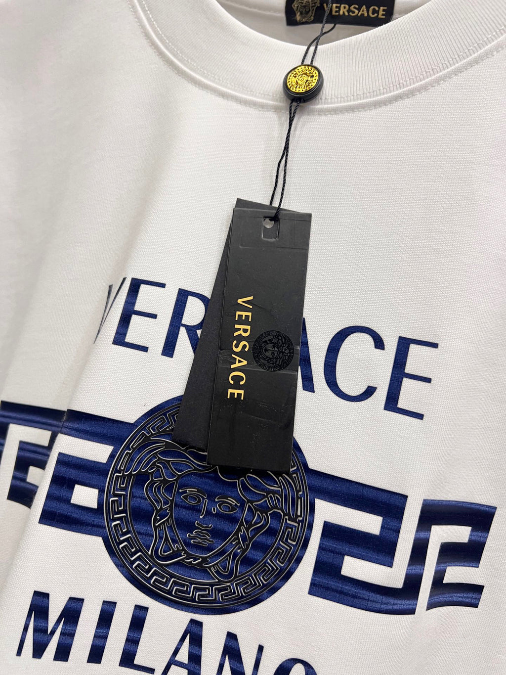 White crewneck T-shirt with large Versace Milano graphic and attached hang tag