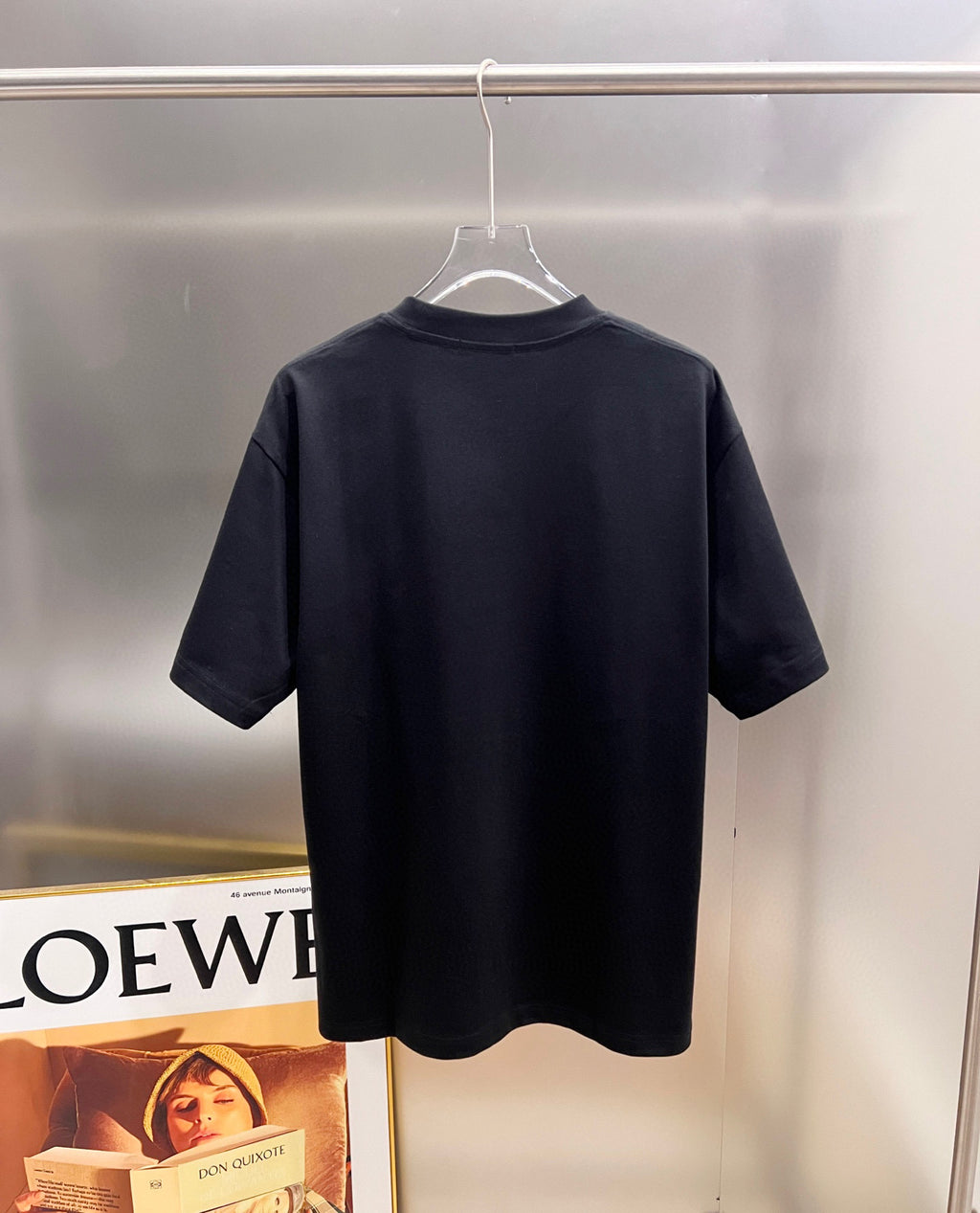 Back of black T-shirt on hanger, no visible print