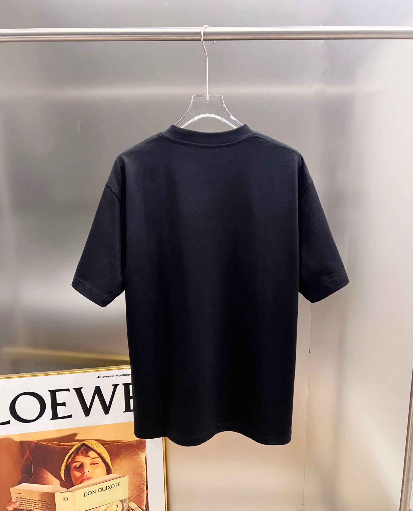 Back of black T-shirt on hanger, no visible print