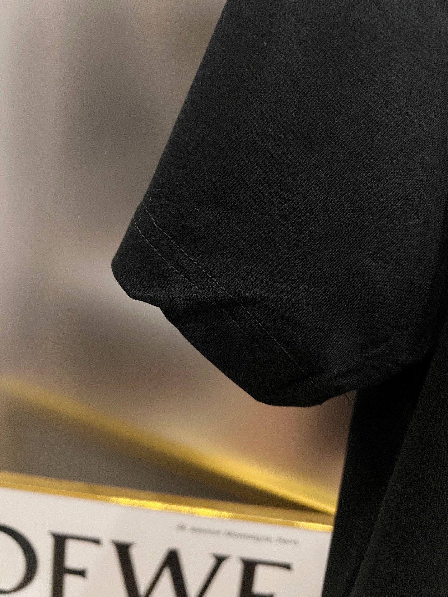 Black T-shirt sleeve and hem seam detail