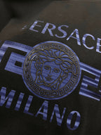 Black T-shirt close-up of circular medallion graphic and blue text