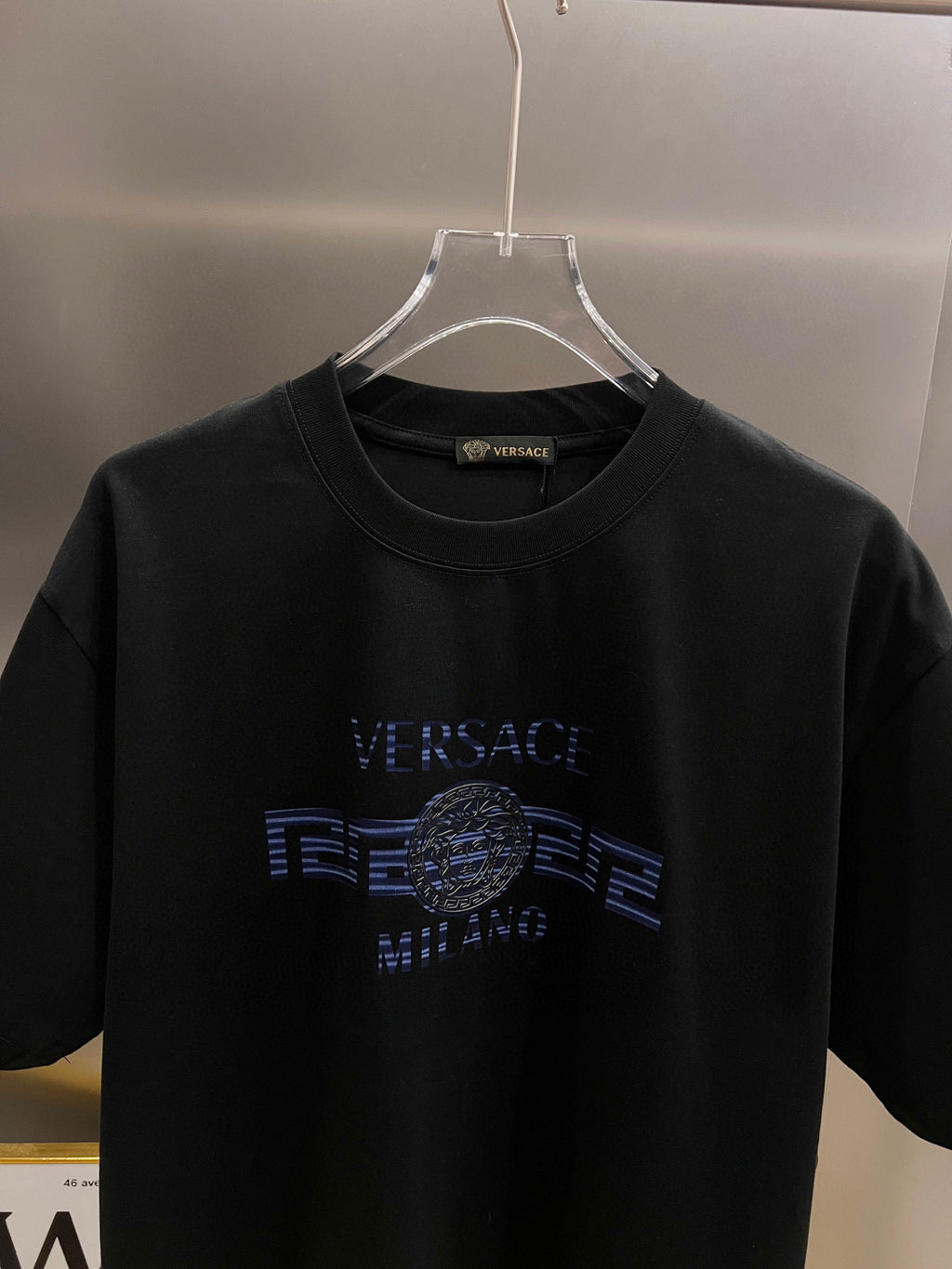 Black T-shirt front view with blue 'VERSACE' and medallion