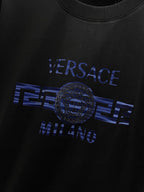 Black T-shirt close-up of blue 'VERSACE MILANO' and medallion