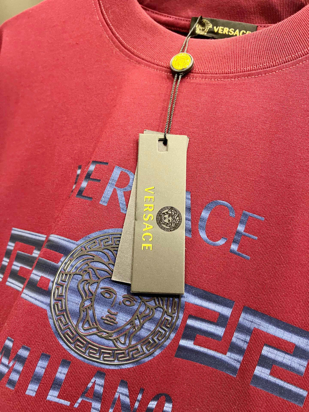 Magenta Versace T-shirt close-up with Medusa logo and neckline tag