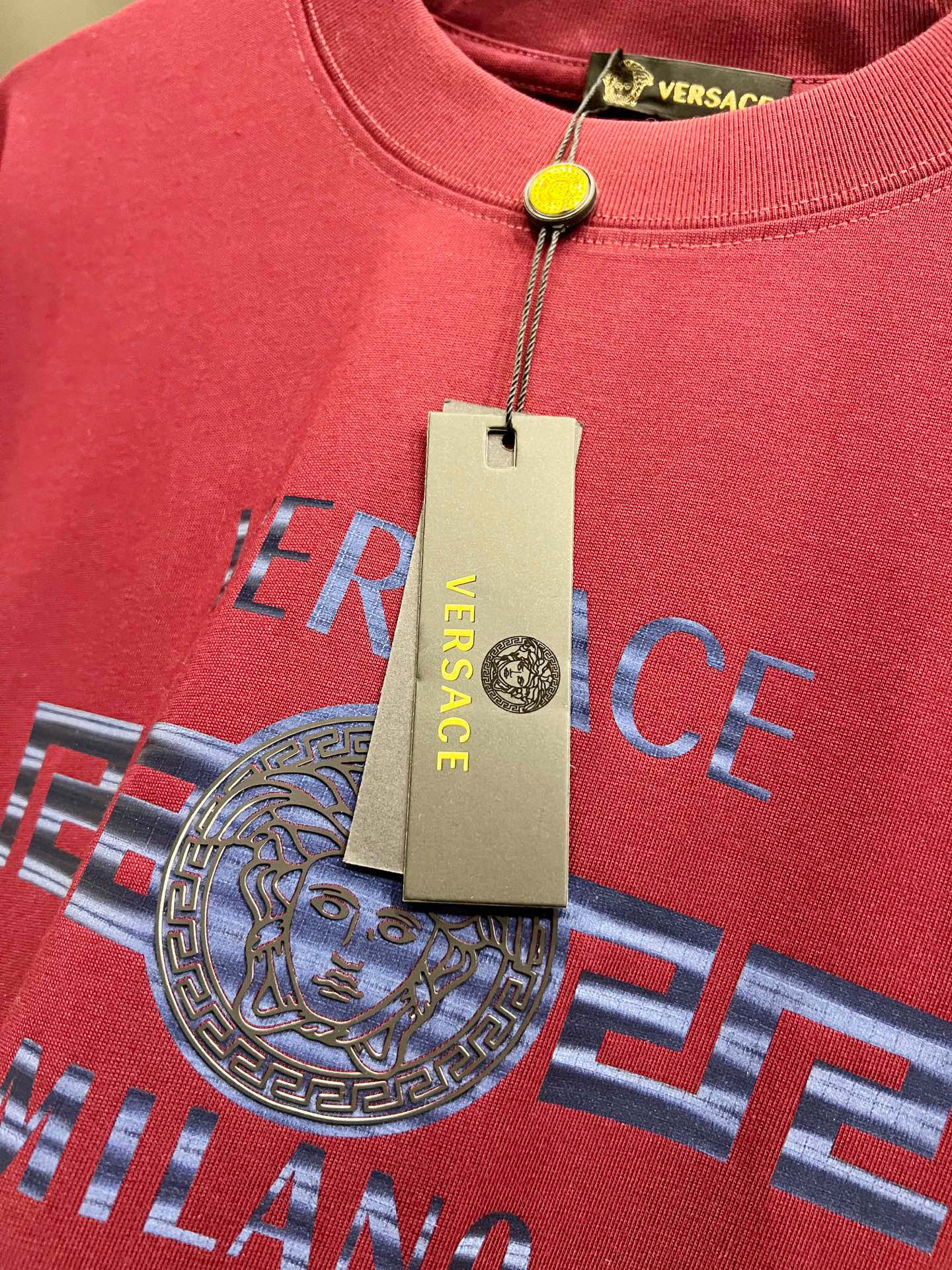 Magenta Versace T-shirt close-up with Medusa logo and neckline tag