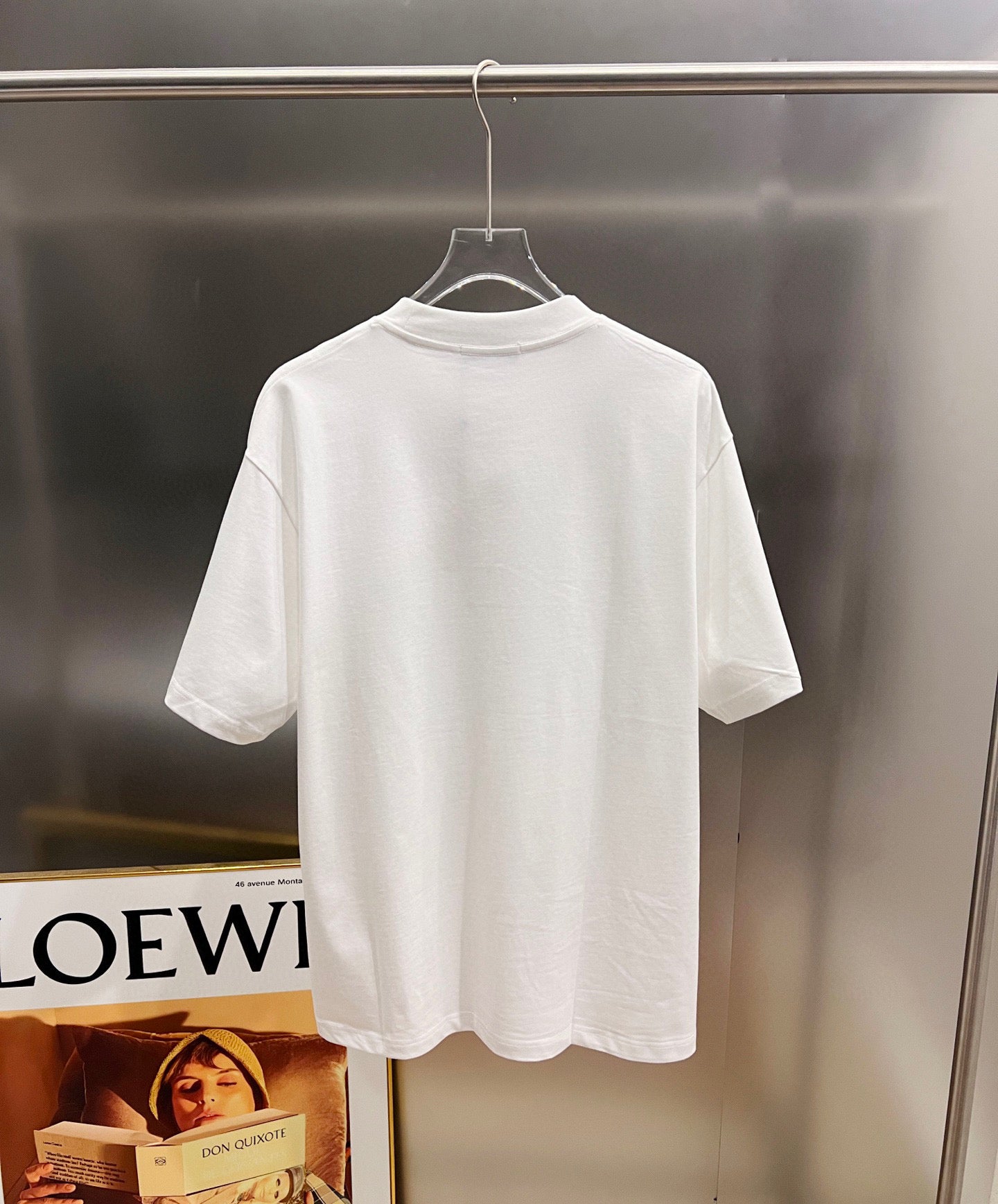 White short-sleeve T-shirt on a hanger, crew neck with plain back