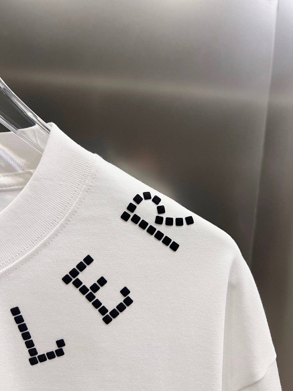 White short-sleeve T-shirt back with black dotted letter graphic