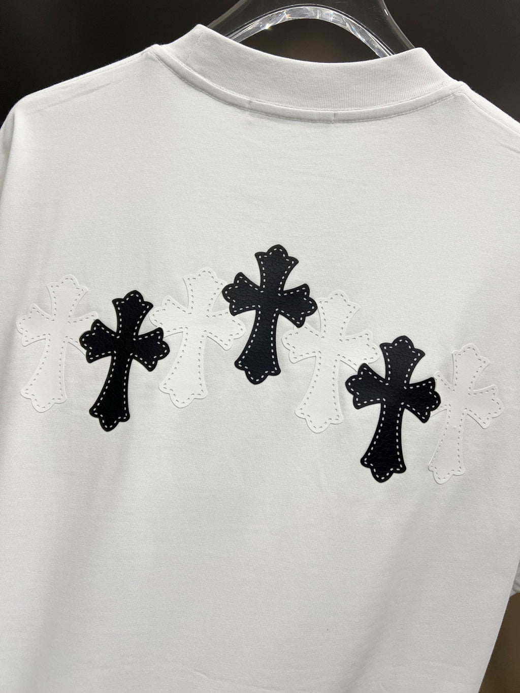 White graphic T-shirt, back view with three black cross designs with light lace outlines