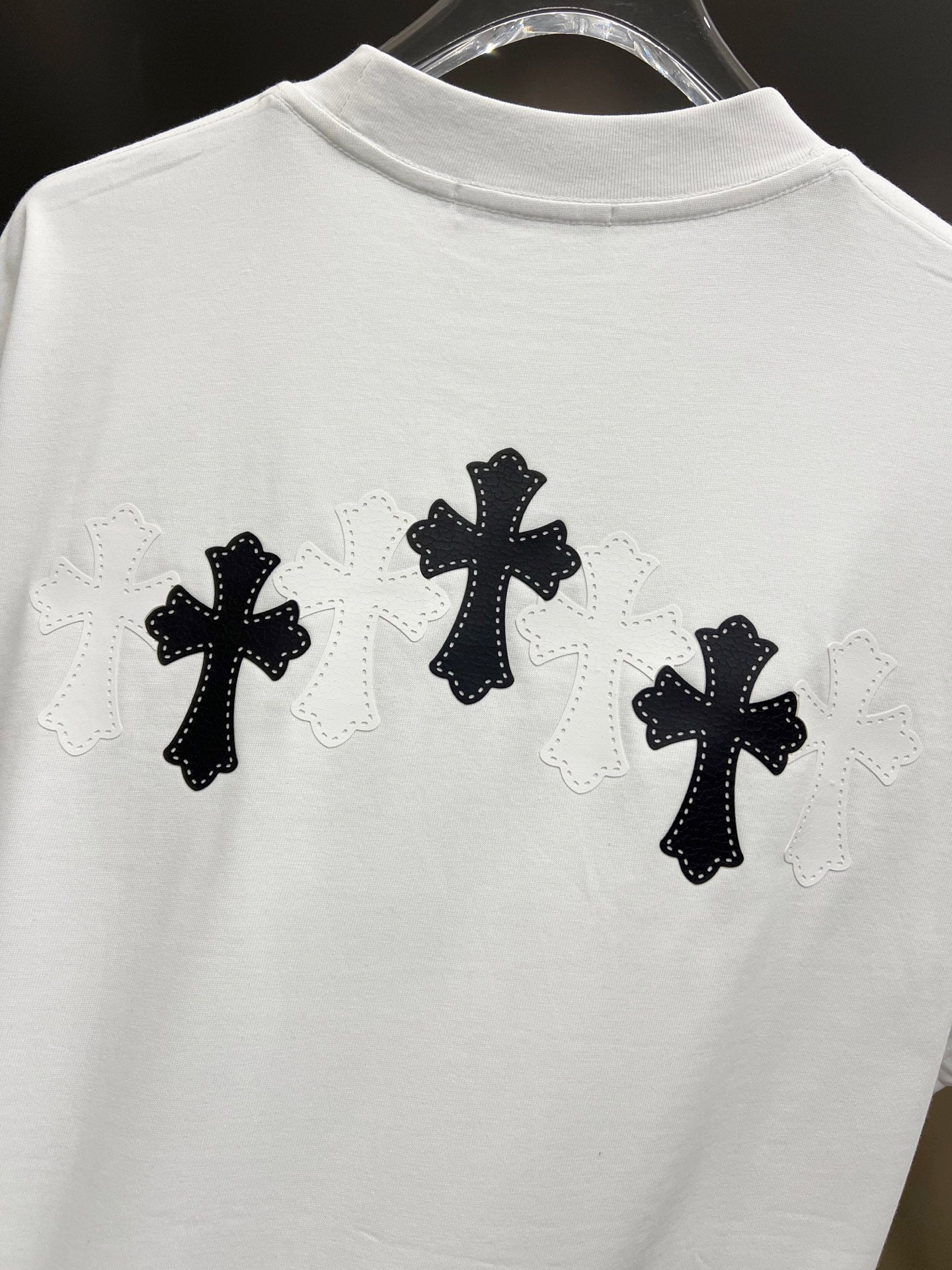 White graphic T-shirt, back view with three black cross designs with light lace outlines