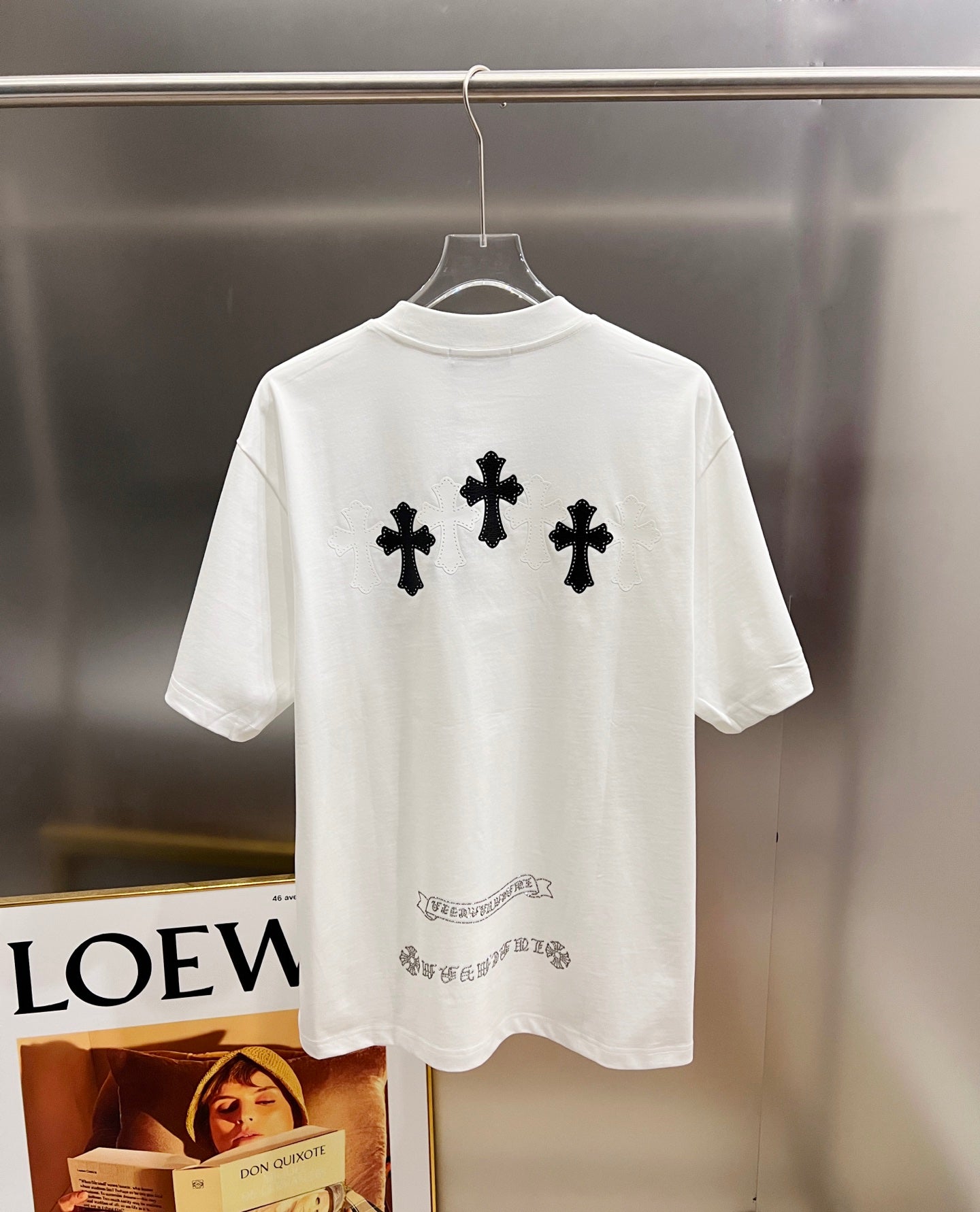 White graphic T-shirt, back view with three black cross designs and small text below