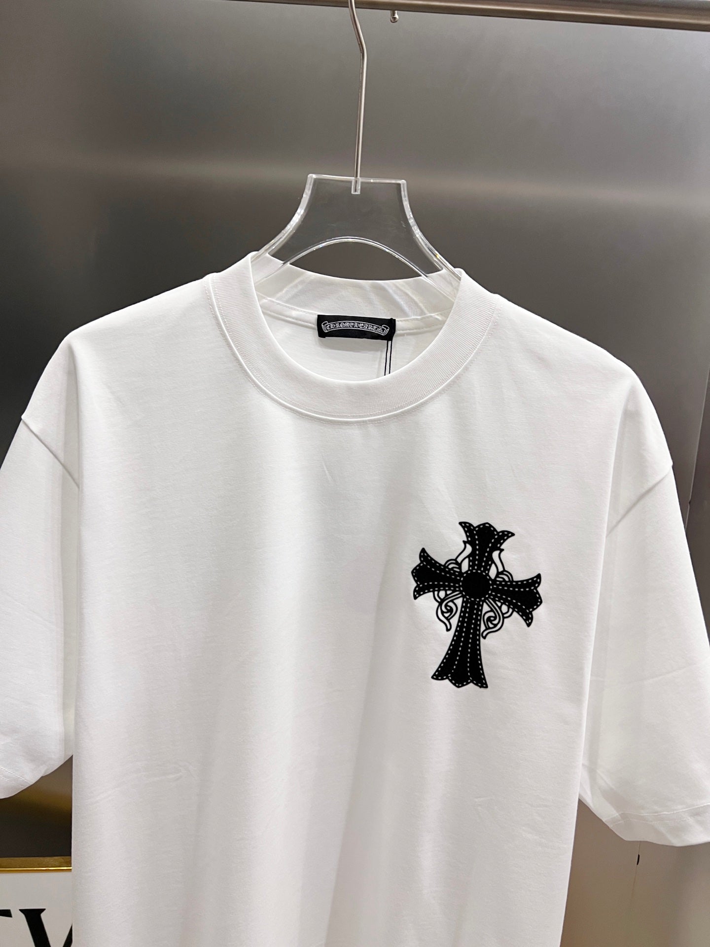 White graphic T-shirt front view with black cross design at the center chest