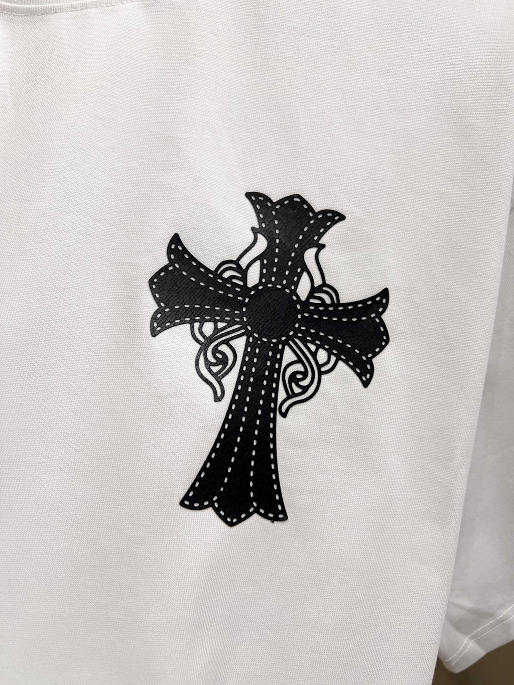 White graphic T-shirt with large black cross design on the front