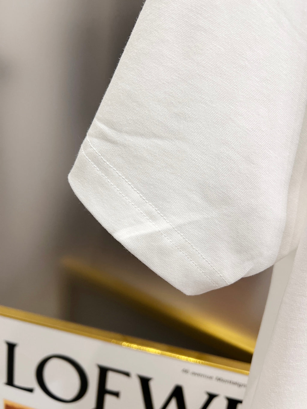 White T-shirt sleeve and hem close-up with stitched cuff detail