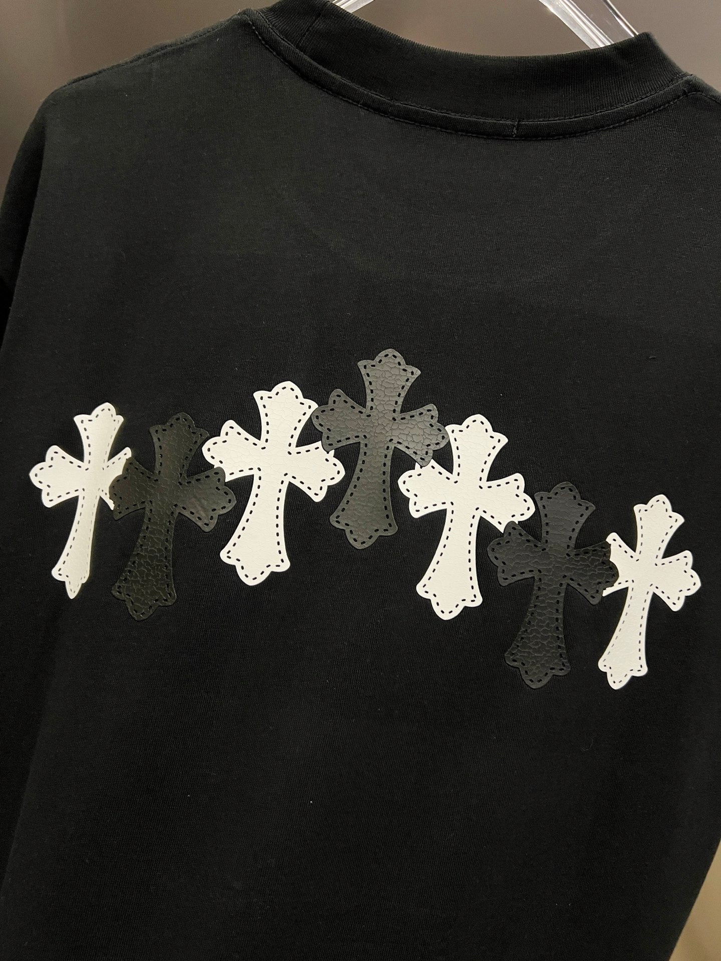 Black T-shirt with large white cross appliqué graphic on back