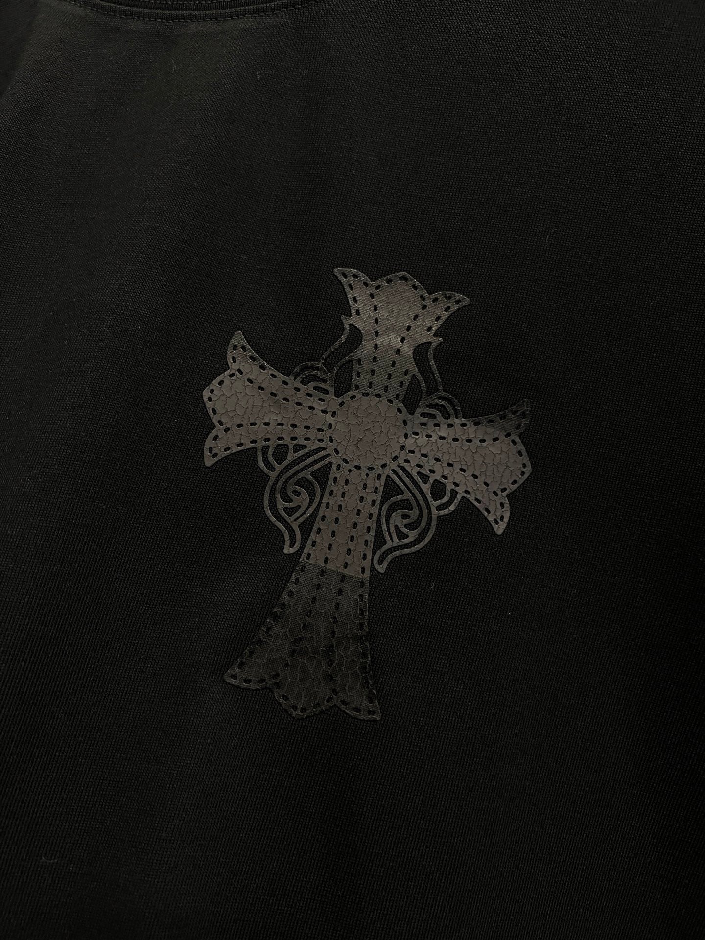 Black T-shirt with subtle dark cross pattern on front