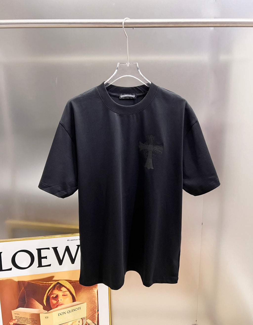 Black short-sleeve T-shirt with small dark cross logo on chest