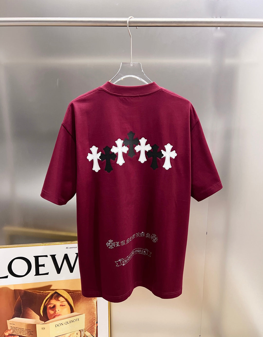 Burgundy short-sleeve T-shirt, back print with white and black crosses and small text.