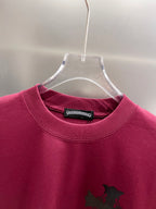Burgundy short-sleeve T-shirt neckline with black cross graphic and interior tag.