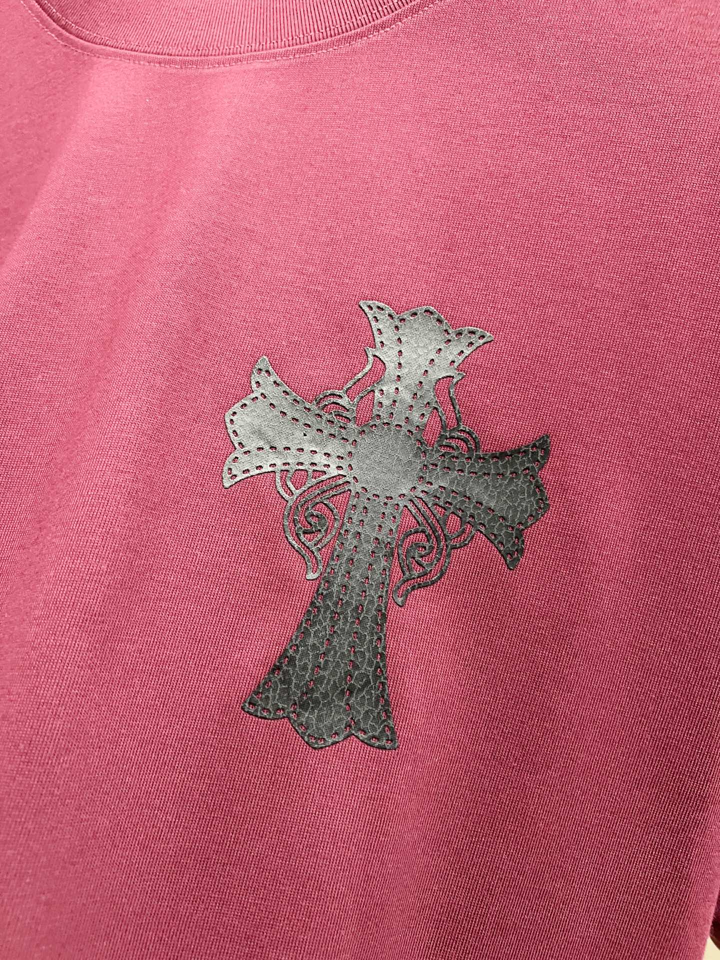 Burgundy T-shirt with light gray cross embroidery with small pink accents.