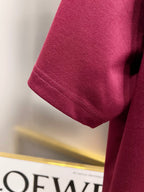 Burgundy short-sleeve T-shirt sleeve with stitched hem detail.