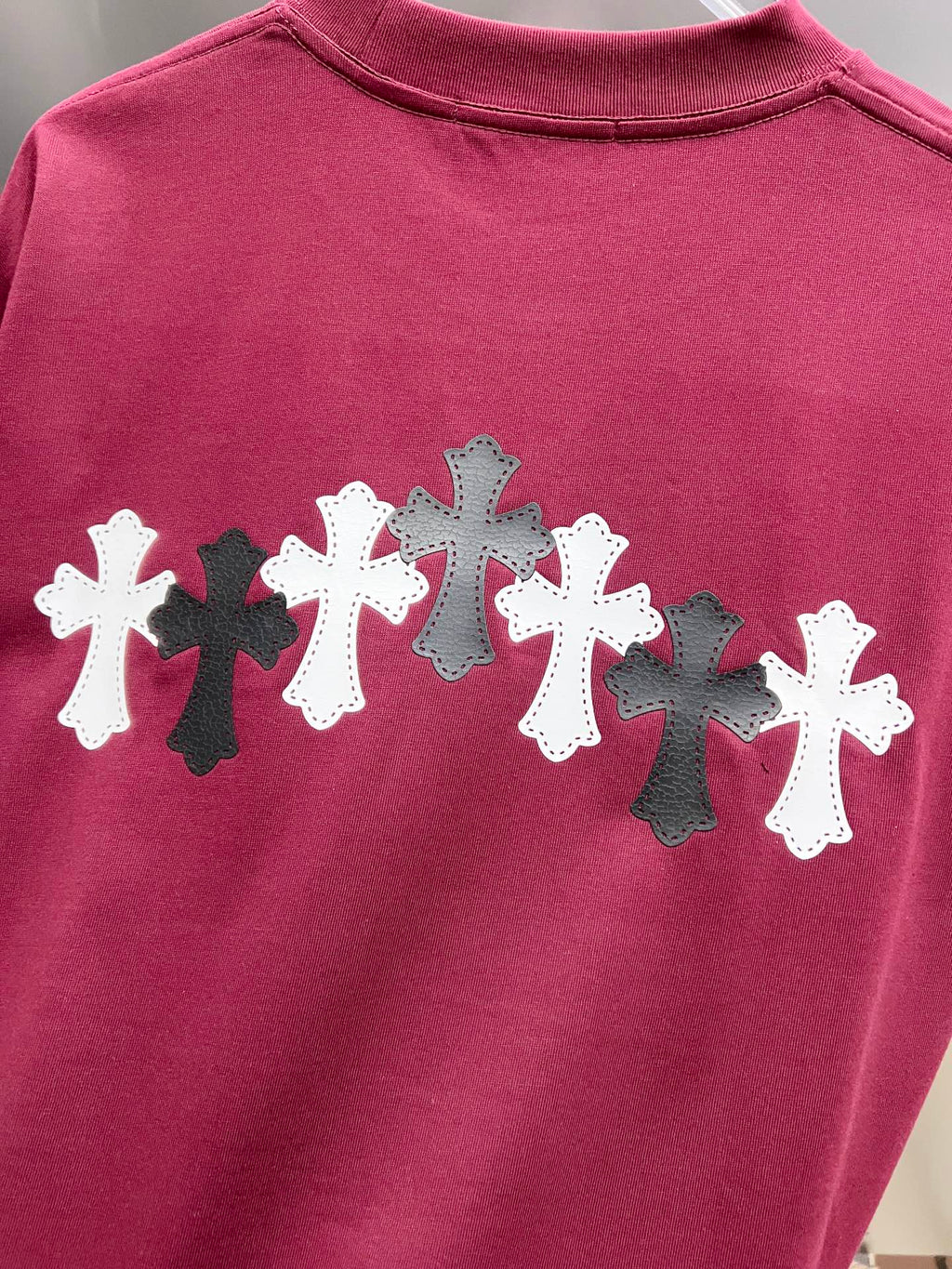 Burgundy T-shirt back print featuring alternating white and black crosses.