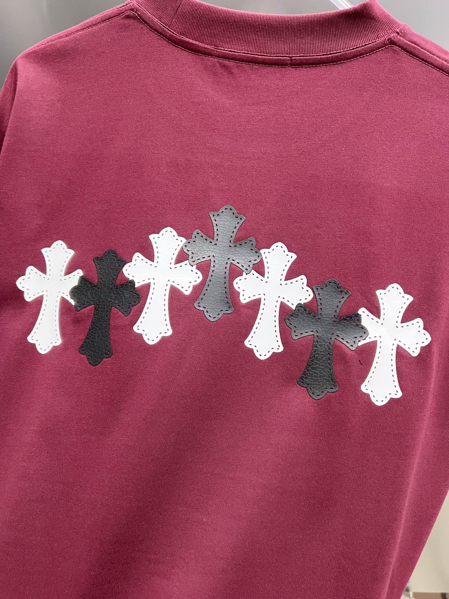 Burgundy T-shirt back print featuring alternating white and black crosses.