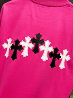Pink short-sleeve T-shirt with row of black and white cross patches on the back