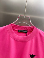 Pink short-sleeve T-shirt with crew neck and black cross graphic detail