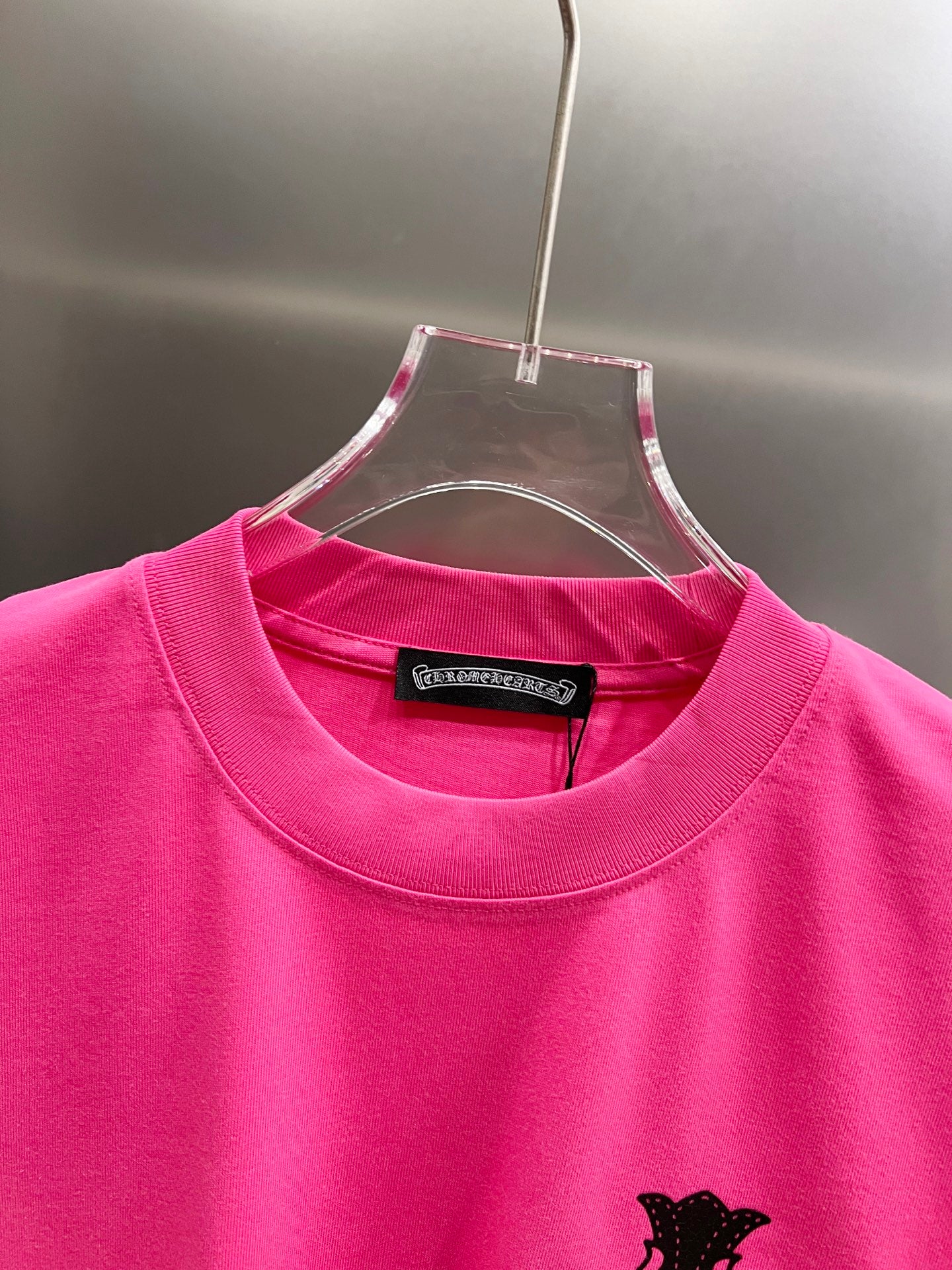 Pink short-sleeve T-shirt with crew neck and black cross graphic detail