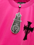 Pink short-sleeve T-shirt with hanging tag charm and black cross applique