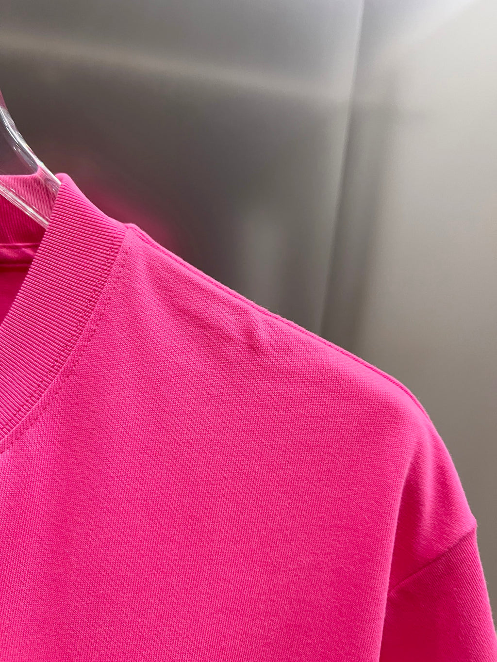 Pink short-sleeve T-shirt from the side on a hanger
