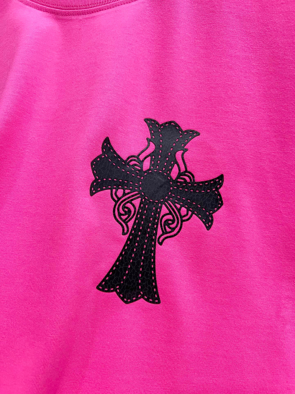 Pink short-sleeve T-shirt with large black cross graphic centered